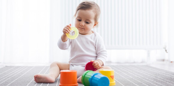Incentivar a los bebés con los juguetes es una alternativa para motivarlos a sentarse solos Bebé sentado jugando con sus juguetes