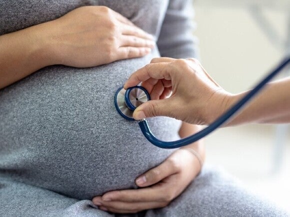 Médico revisando a una mujer embarazada durante una consulta prenatal