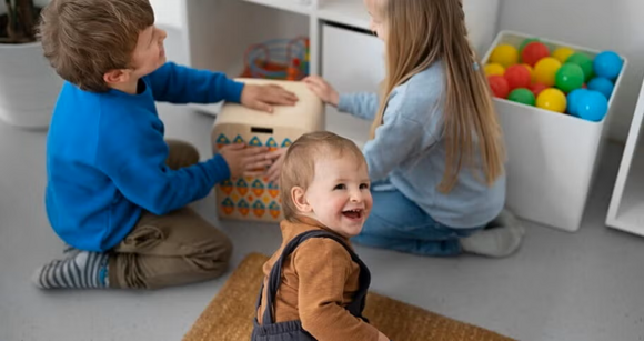Niños pequeños riendo y jugando en un cuarto de juegos.