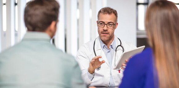 Existen diversas ayudas médicas para facilitar la dilatación. Padres revisando con el médico las ayudas médicas para la dilatación.