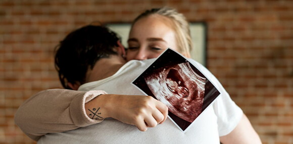 Los bebés arcoíris son la oportunidad de ser padres nuevamente. Pareja abrazados celebrando que tendrán un bebé arcoíris