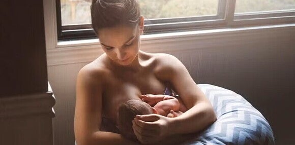 El calostro es la primera comida de tu bebé Mamá amamantando a su bebé recién nacido.