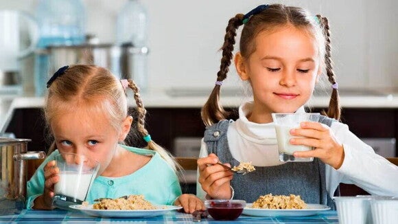 dos niñas comiendo desayuno dos niñas comiendo desayuno