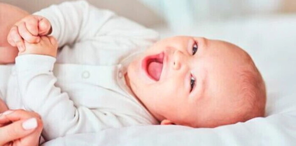 Los hitos del desarrollo del bebé bebé sonriendo en su cama