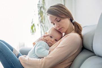 Una madre abrazando a su bebé mientras duerme en su pecho Una madre abrazando a su bebé mientras duerme en su pecho