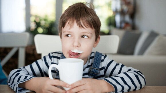 Una buena alimentación es parte integral de un estilo de vida saludable niño lame su bigote de leche