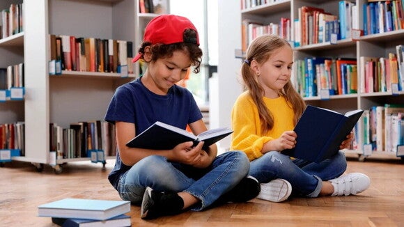 La lectura en niños para su desarrollo intelectual Dos niños leyendo en una biblioteca