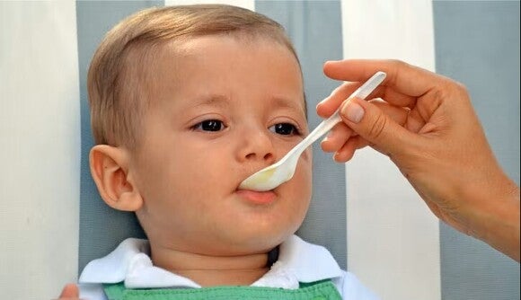 mamá alimentando a su bebé con compotas GERBER