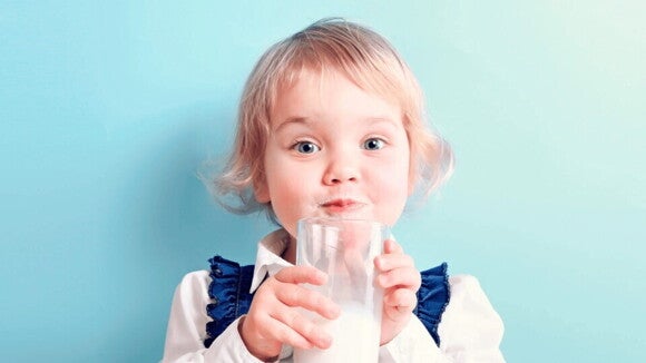 niña tomando leche de un vaso