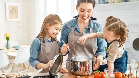 niñas preparando comida con su madre