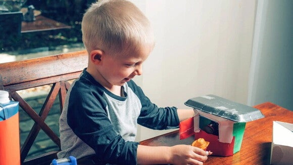niño construye una casita con material reciclado