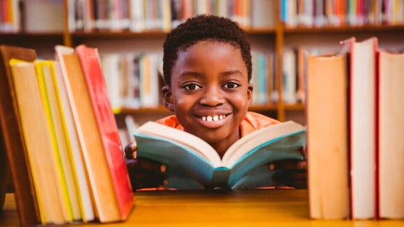 niño junto a libros niño junto a libros