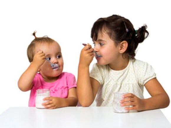 Importancia de snacks saludables para niños Bebé y niña pequeña comiendo un snack.